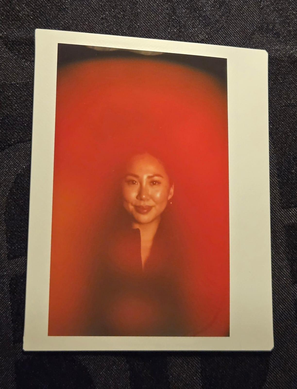 An aura portrait of a smiling person glowing in bright red and orange.