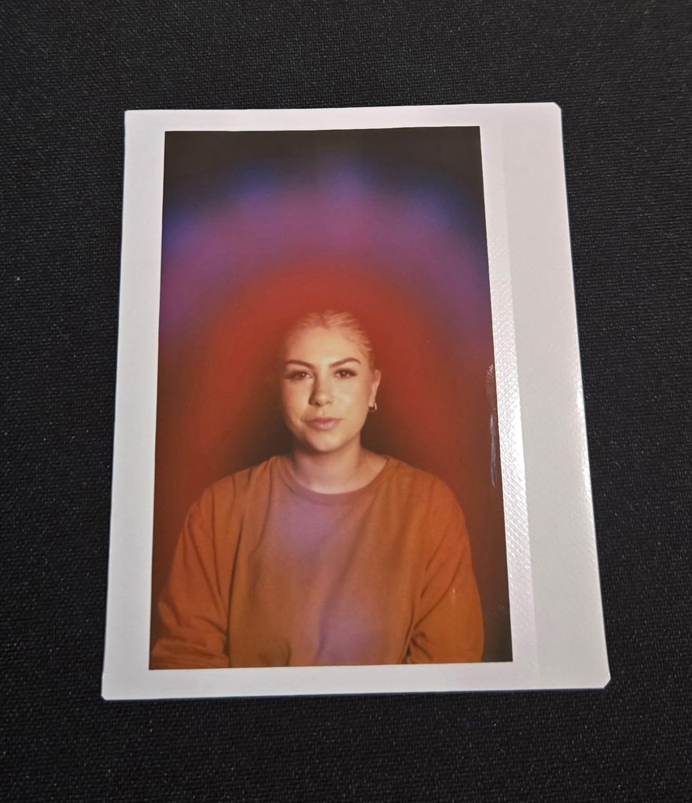 An aura portrait of a person with a red aura fading up into violet and blue.