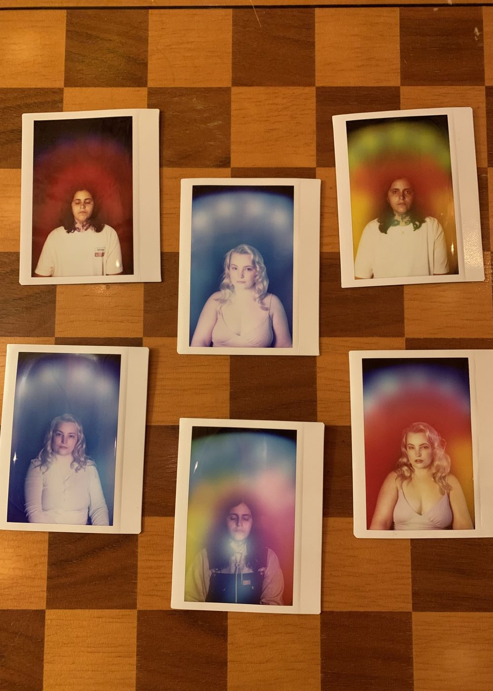 Six aura portraits laid out on a checkerboard table, each a different colour.