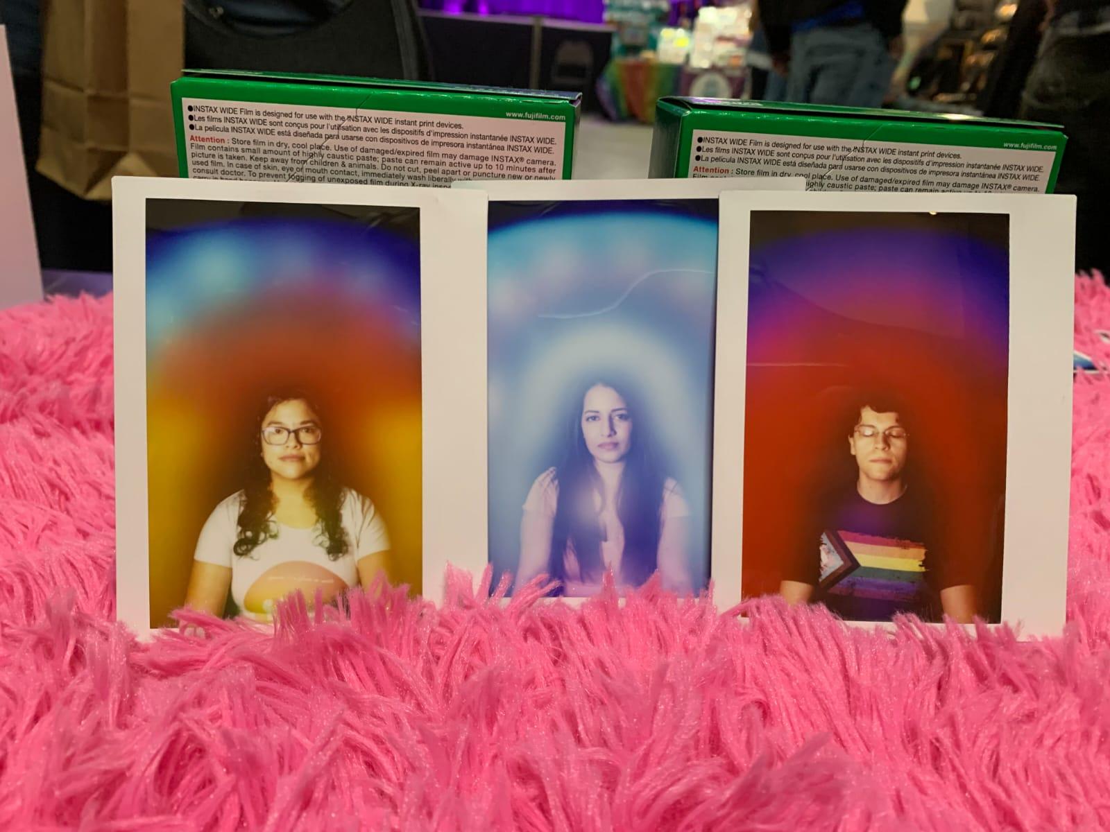 Three aura portraits standing in a row on a shaggy pink rug, one gold, one blue, one red.